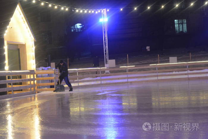 一名冰场工作人员正在计算一台冰场冰加工机器后冰中一个雪冰团的遗骸。